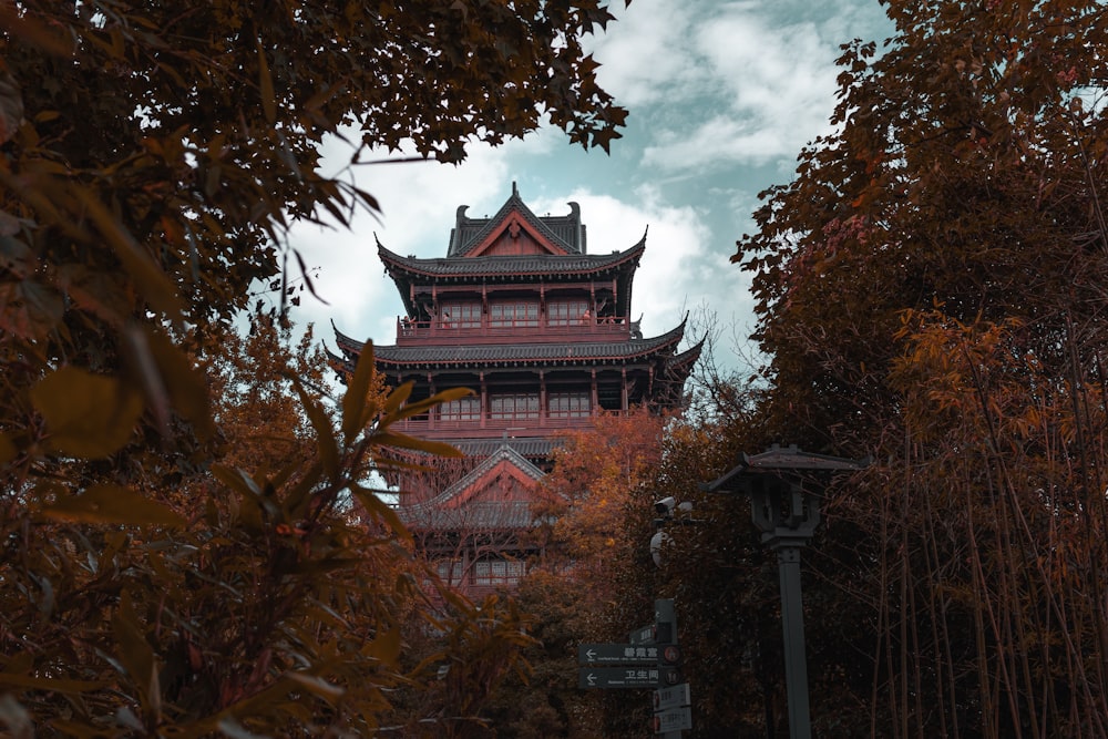 a tall building surrounded by trees and a cloudy sky