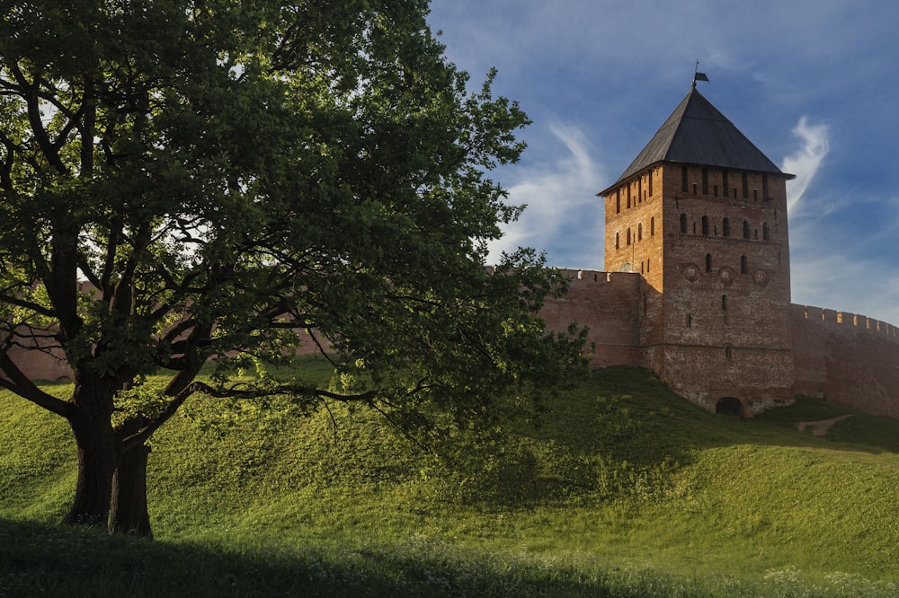 a large brick building sitting on top of a lush green hillside