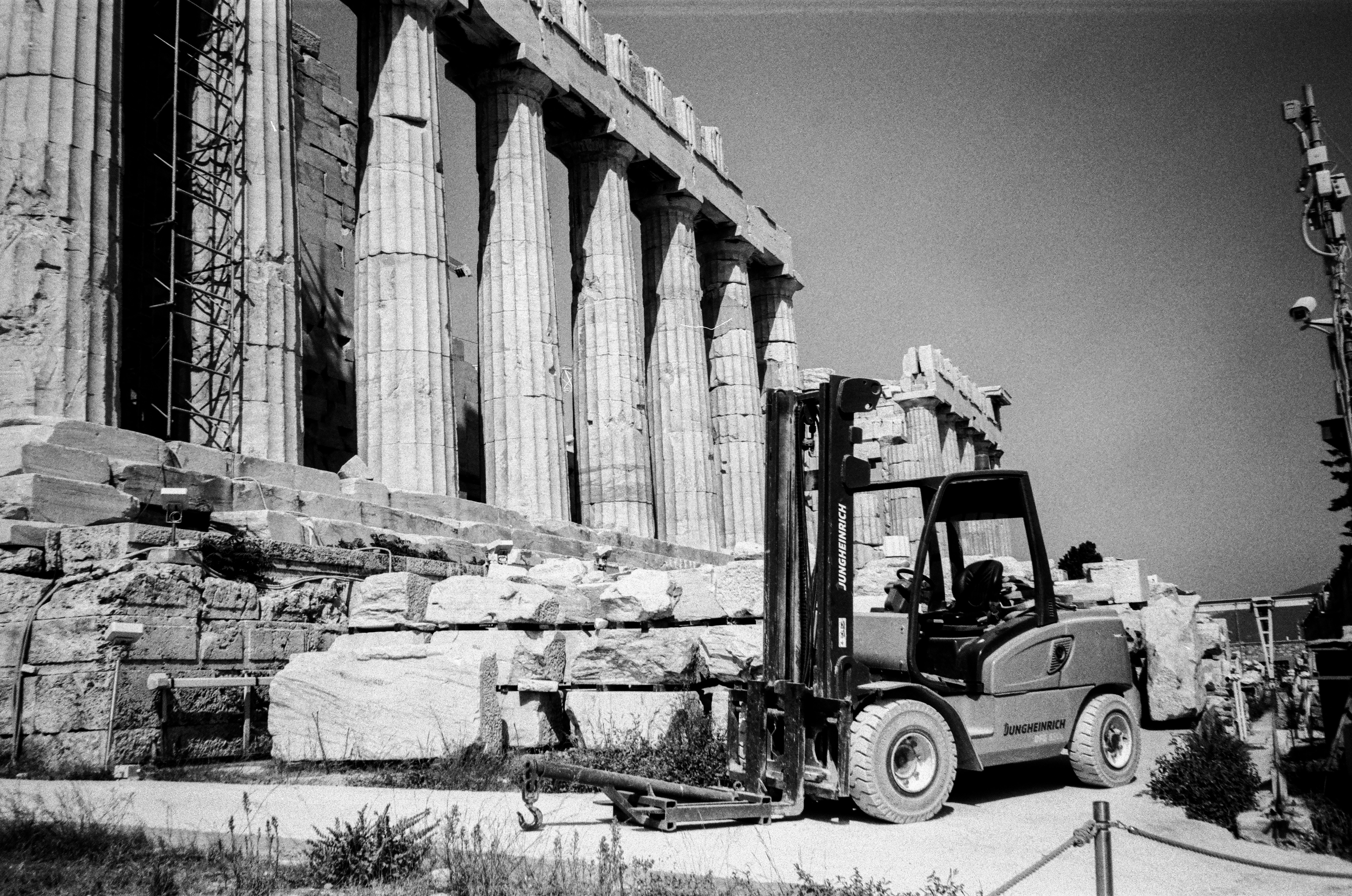 a black and white photo of a forklift in front of a building
