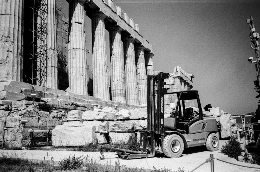 a black and white photo of a forklift in front of a building