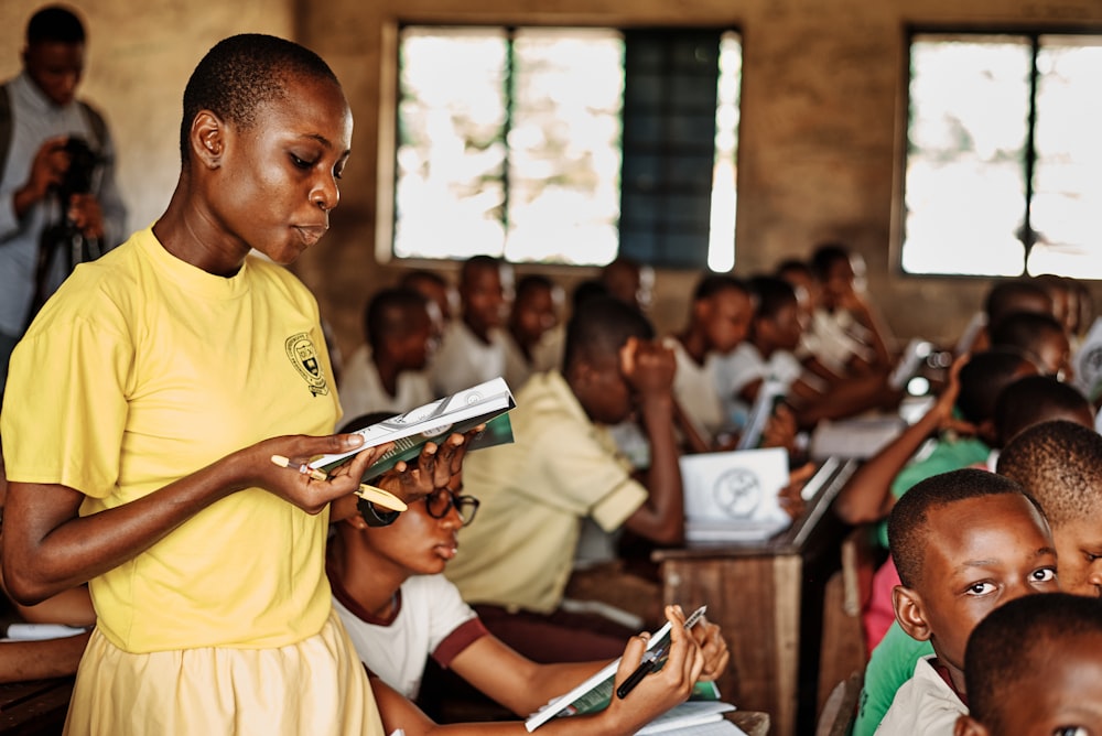 a woman standing in front of a group of children