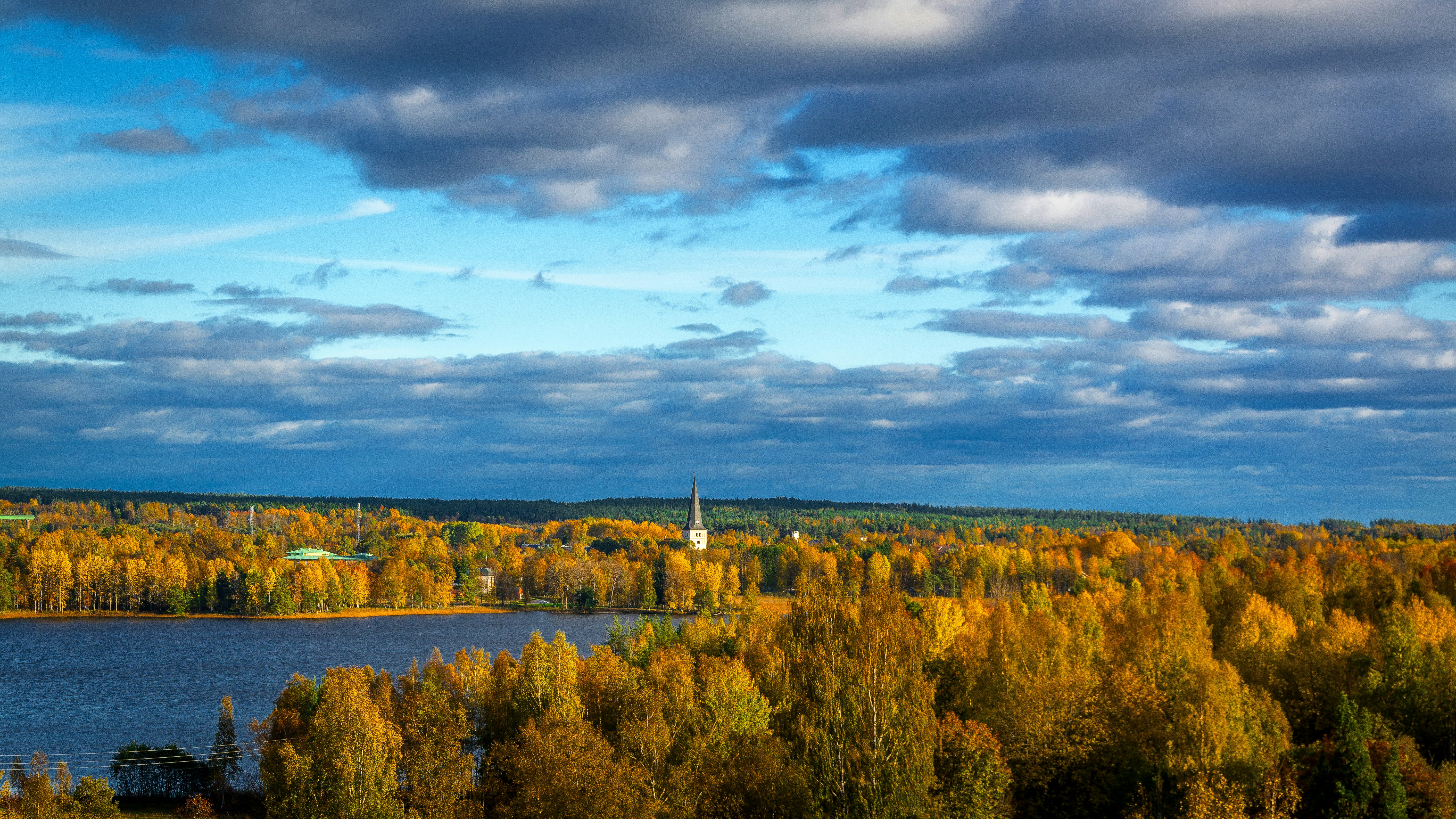 Un lago circondato da alberi con una chiesa sullo sfondo