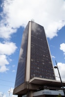 a very tall building sitting under a cloudy blue sky