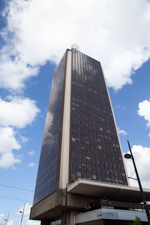 a very tall building sitting under a cloudy blue sky