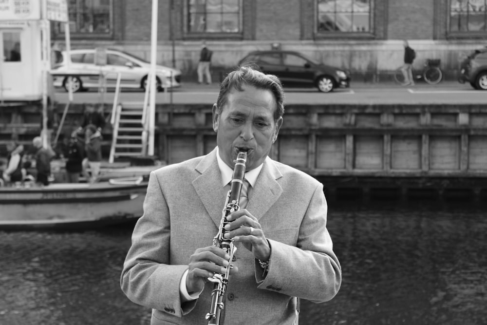 Un hombre de traje y corbata tocando un saxofón