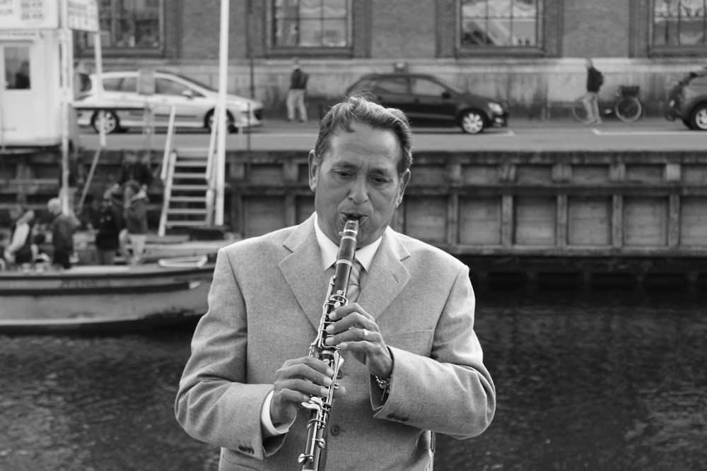 a man in a suit and tie playing a saxophone