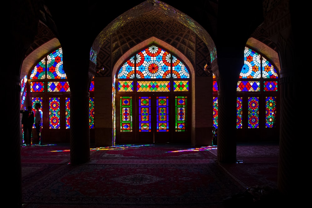 a room with stained glass windows and a rug on the floor