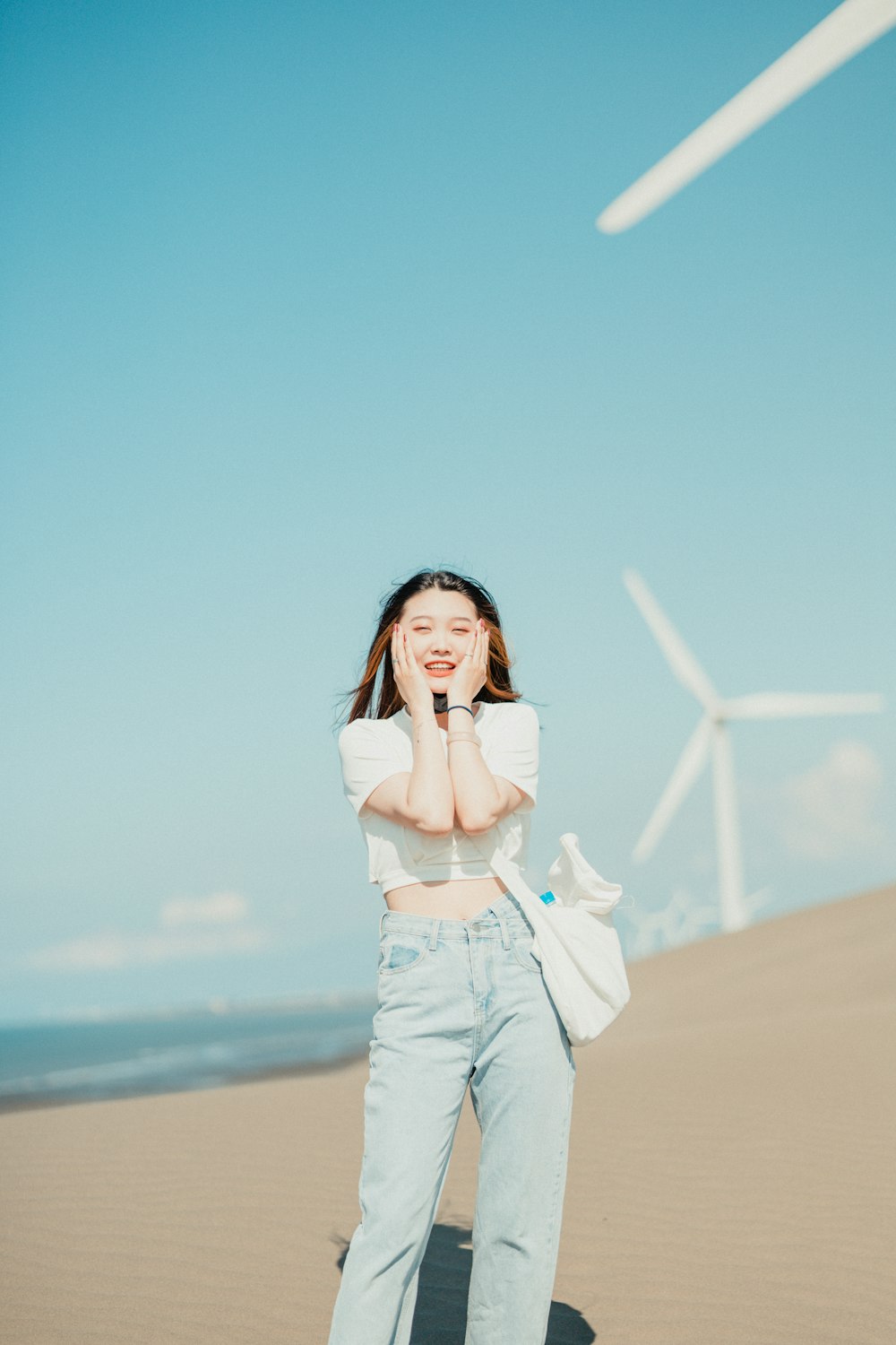 a woman standing on top of a sandy beach