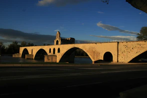 An ancient stone bridge arching over a clear mountain river.