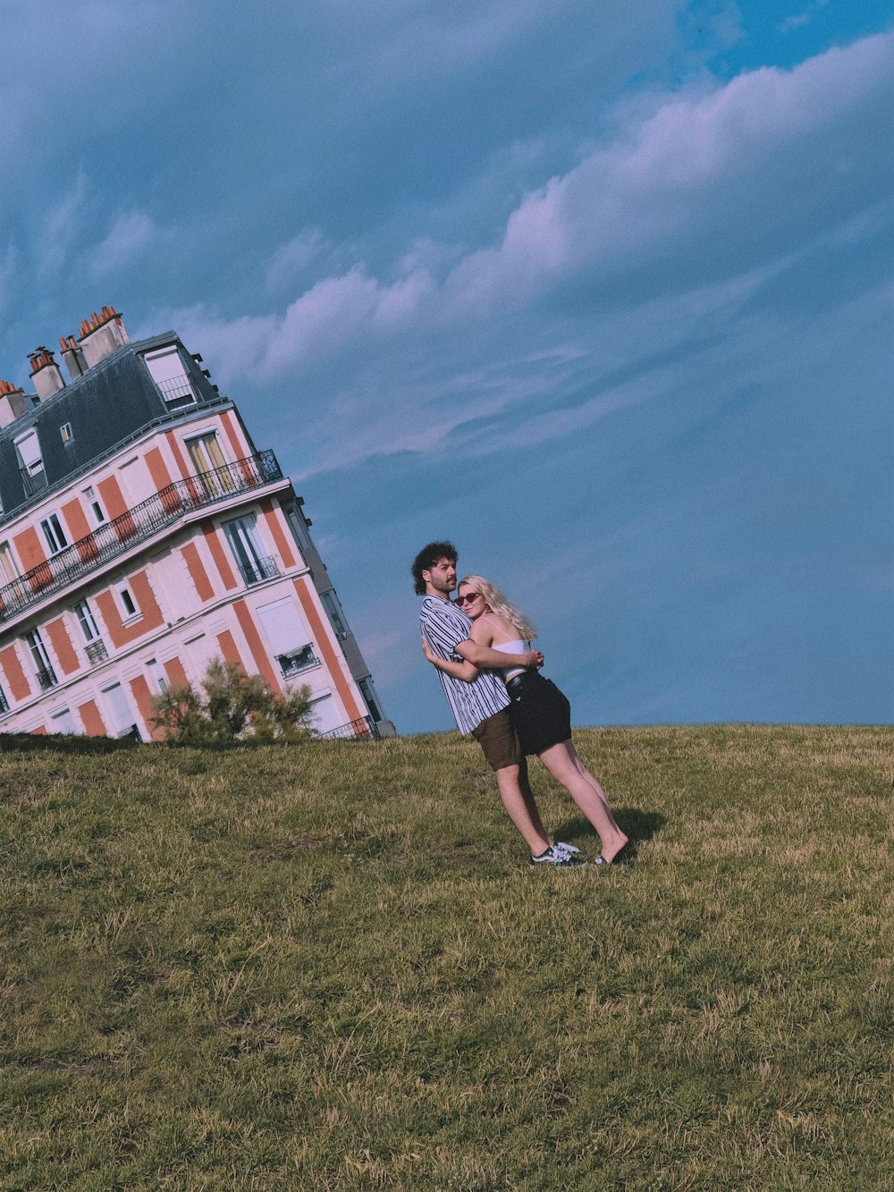 a man and woman standing in front of a tall building