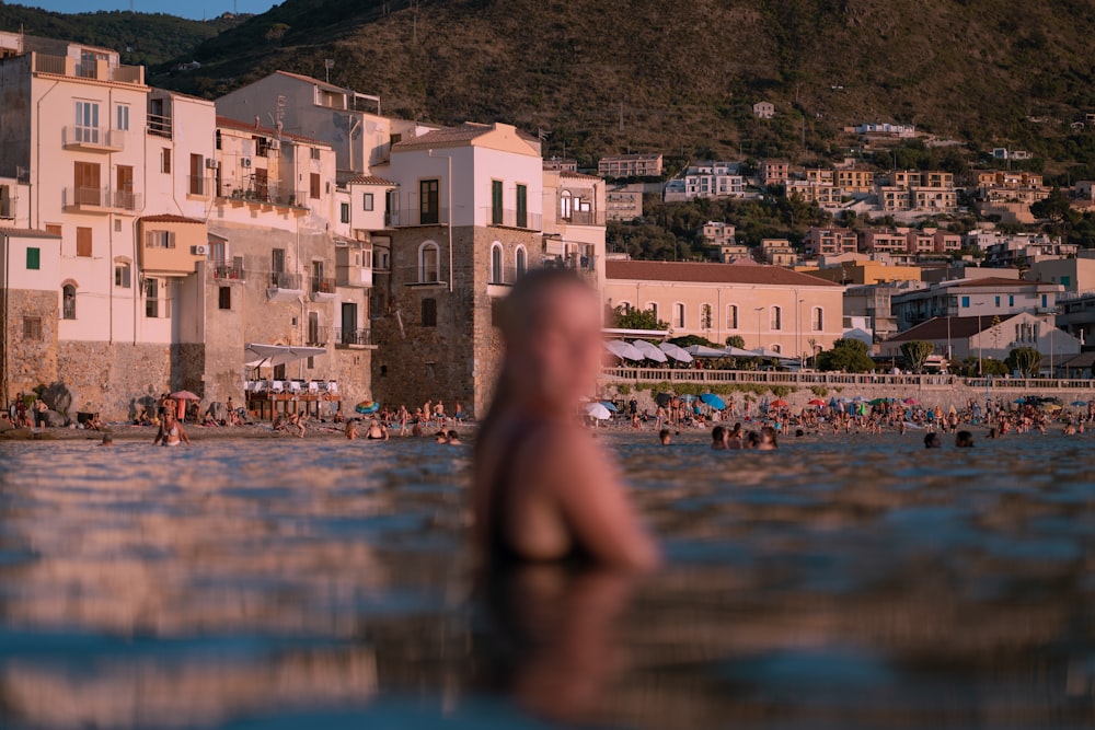 a man standing in the water in front of a city