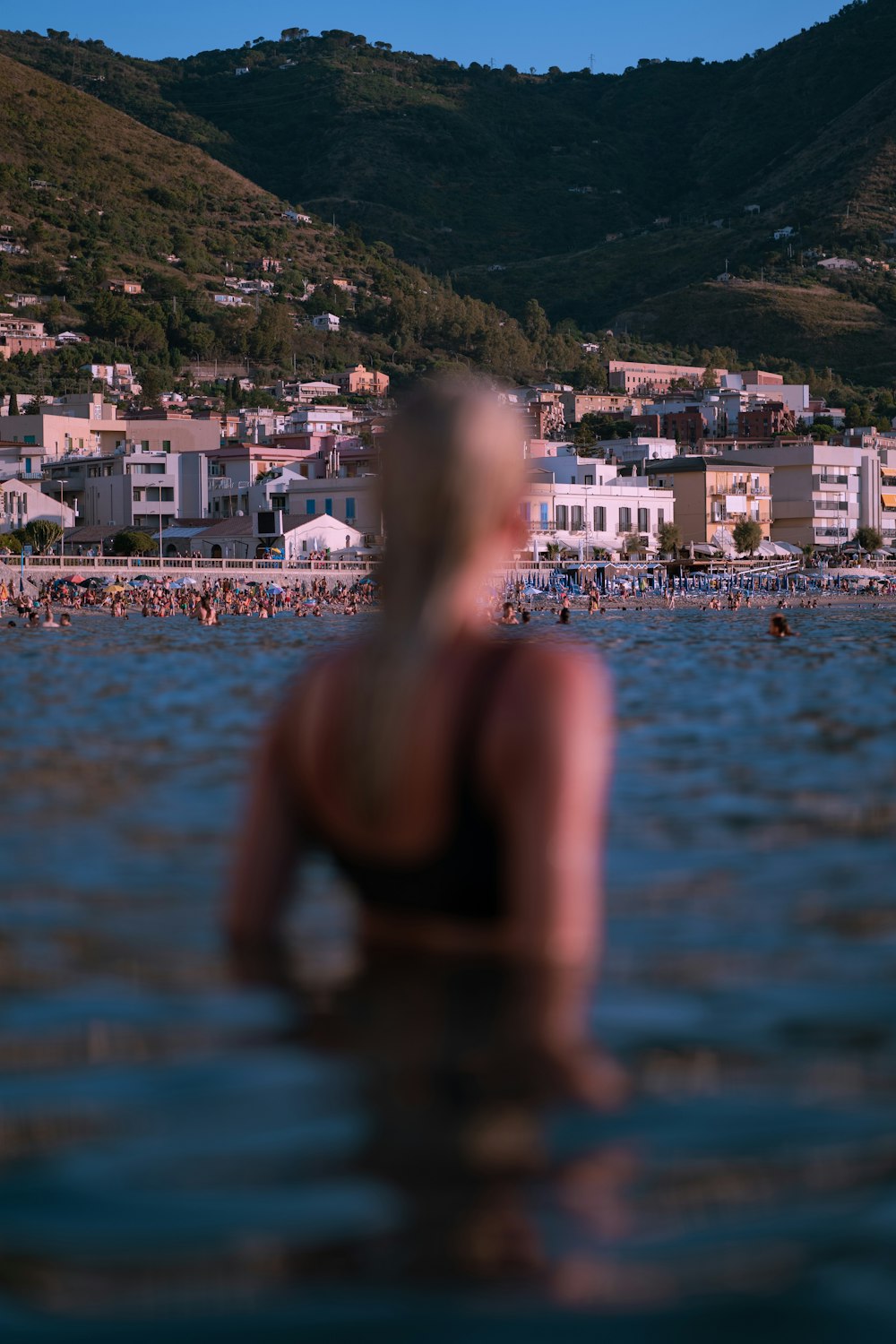 Eine Person im Wasser mit einer Stadt im Hintergrund