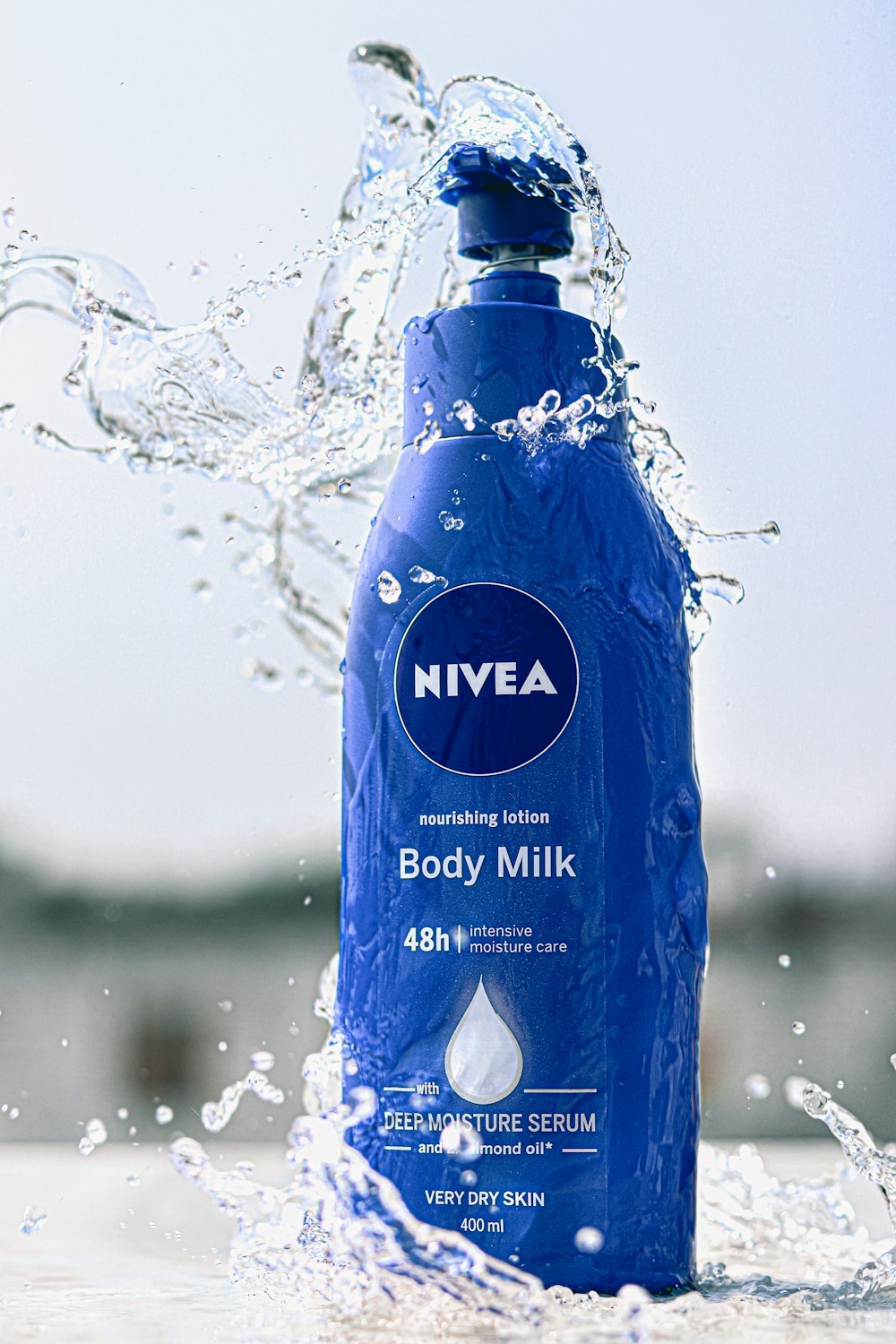 a bottle of nivea body milk splashing out of the water