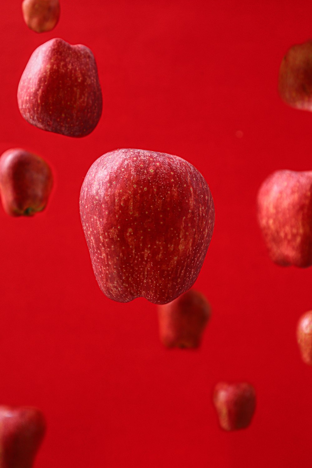 a group of red apples floating in the air