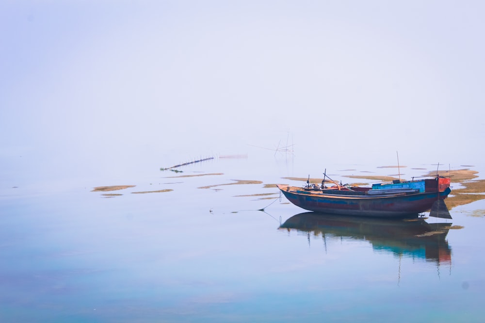 a small boat floating on top of a body of water