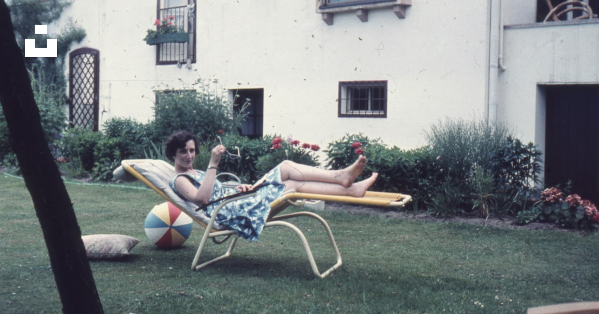 A woman laying on a lawn chair in a yard photo Free Chair Image on A woman laying on a lawn chair in a yard photo Free Chair Image on