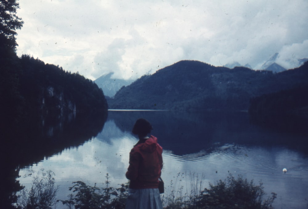 a person standing on a hill overlooking a lake