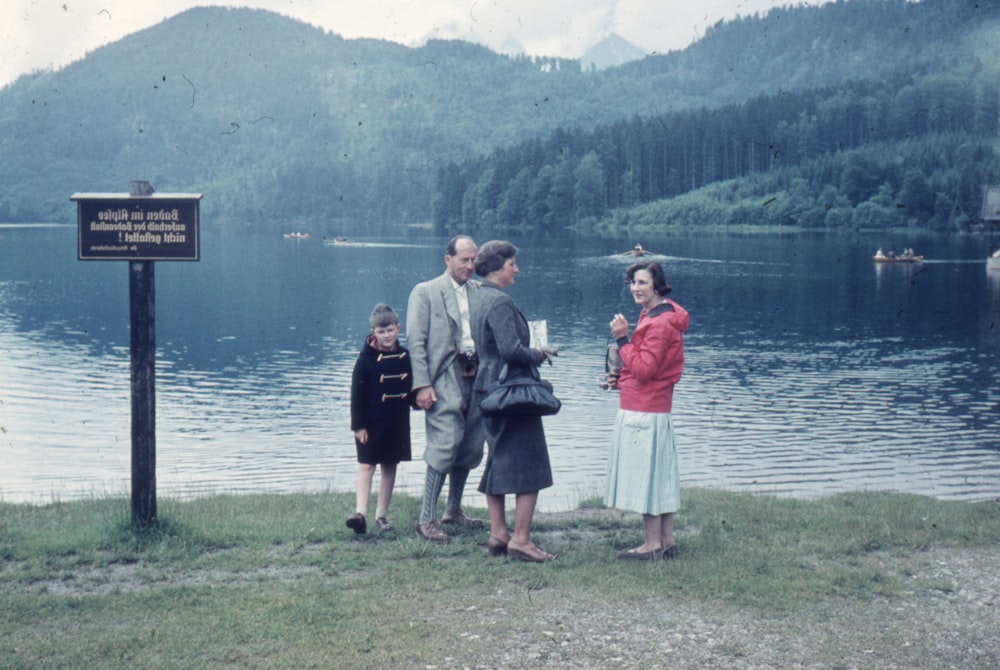 a group of people standing next to a body of water