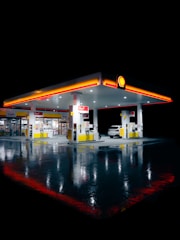 a gas station lit up at night time
