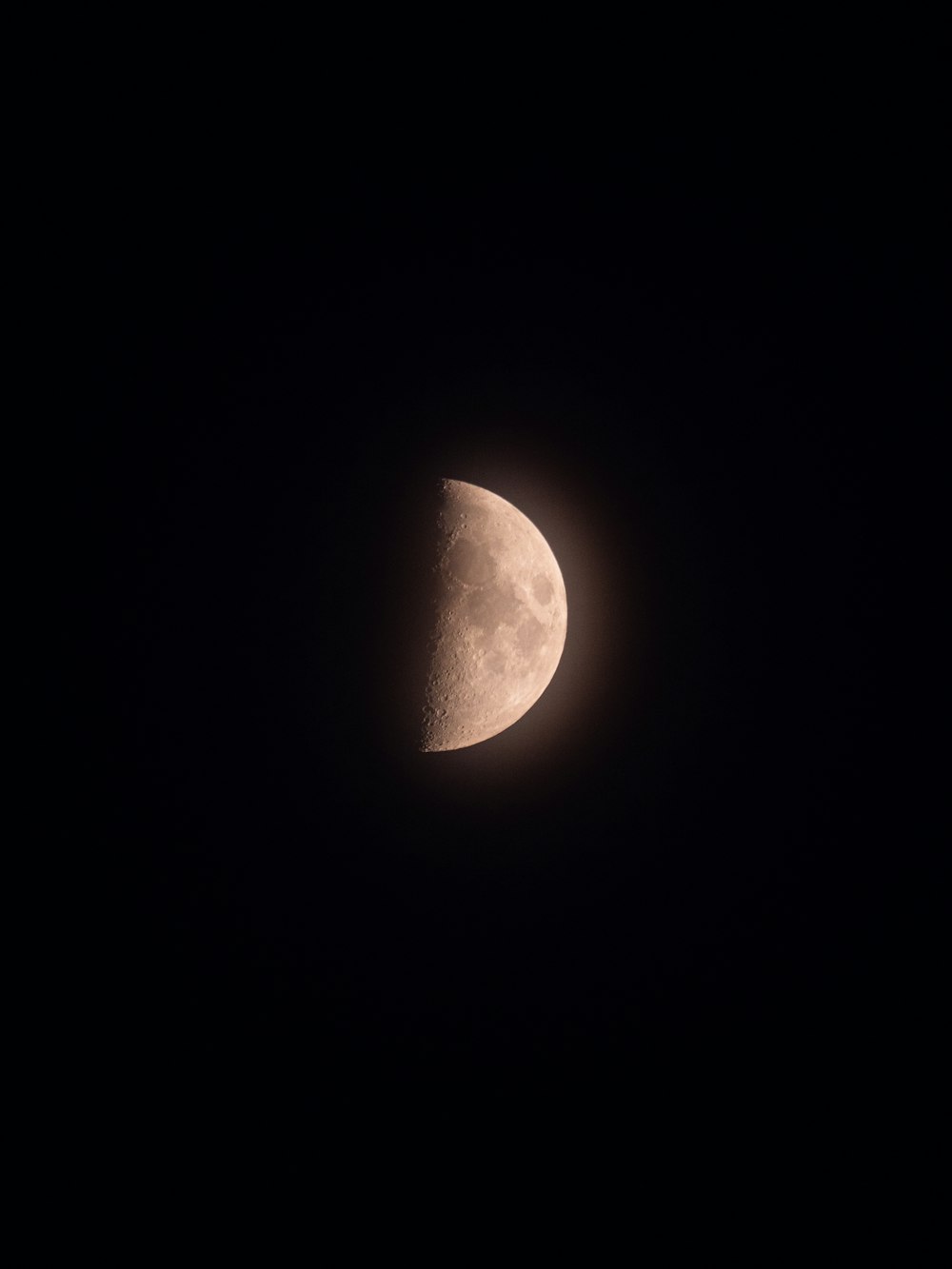 the moon is seen through the dark sky