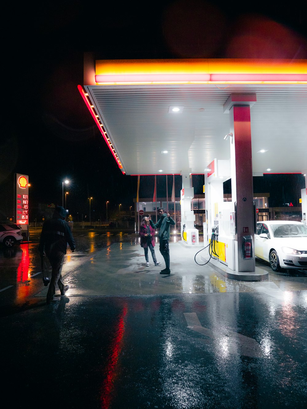a group of people standing at a gas station