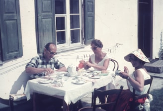 a group of people sitting at a table outside