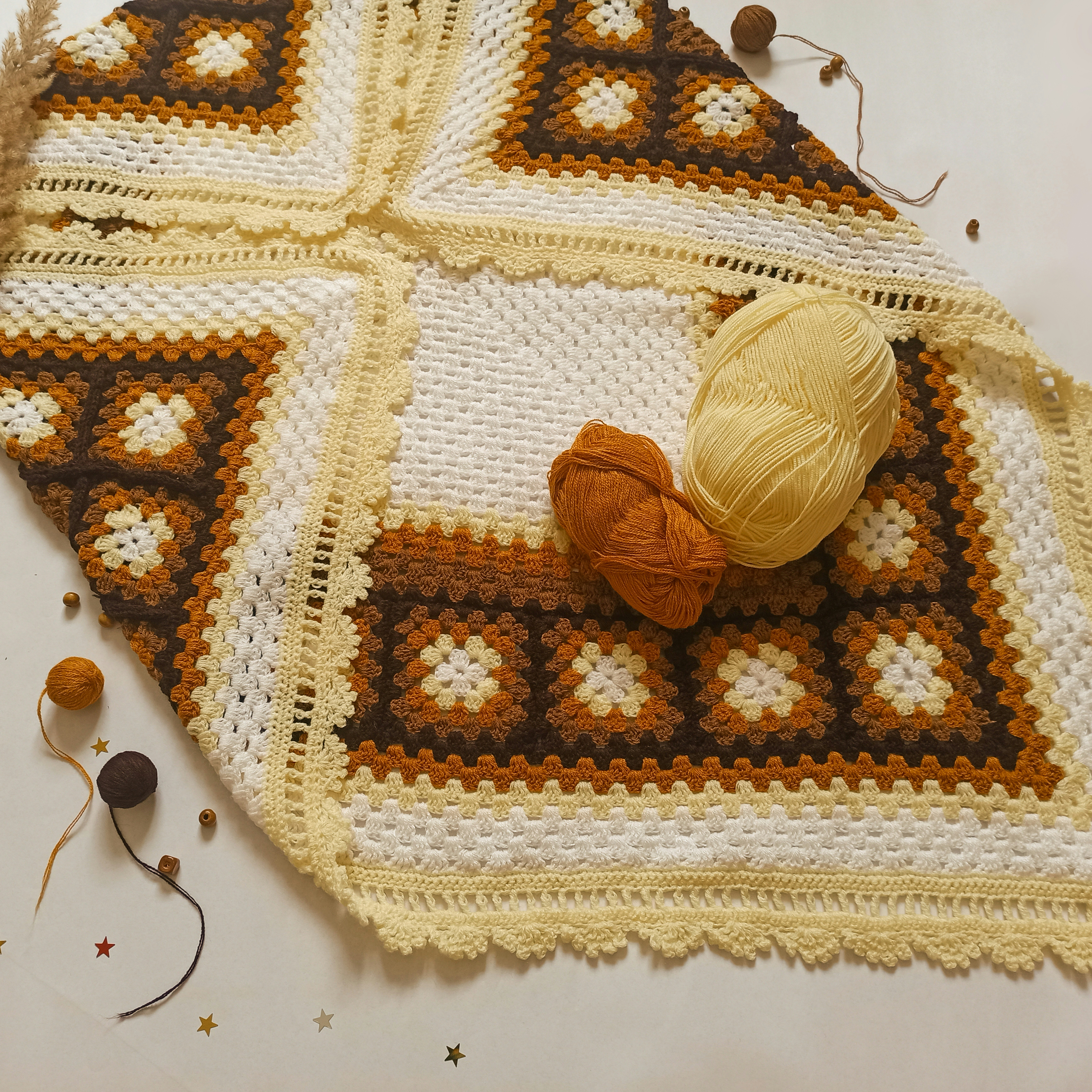 a crocheted blanket with a ball of yarn on top of it