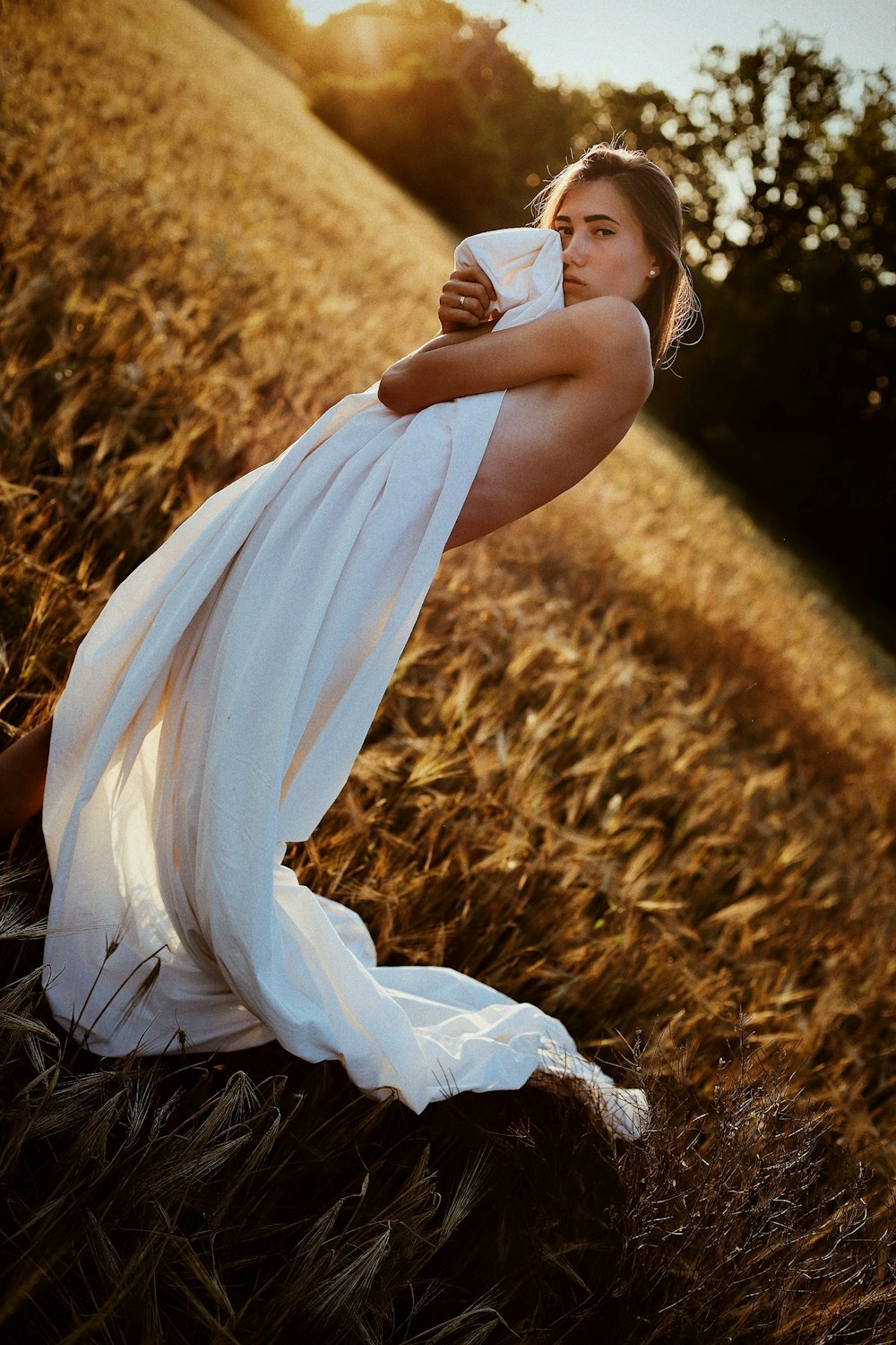 a woman in a white dress standing in a field