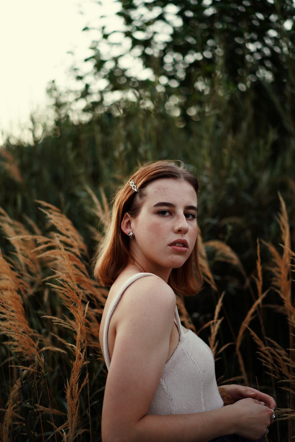 a woman standing in a field of tall grass