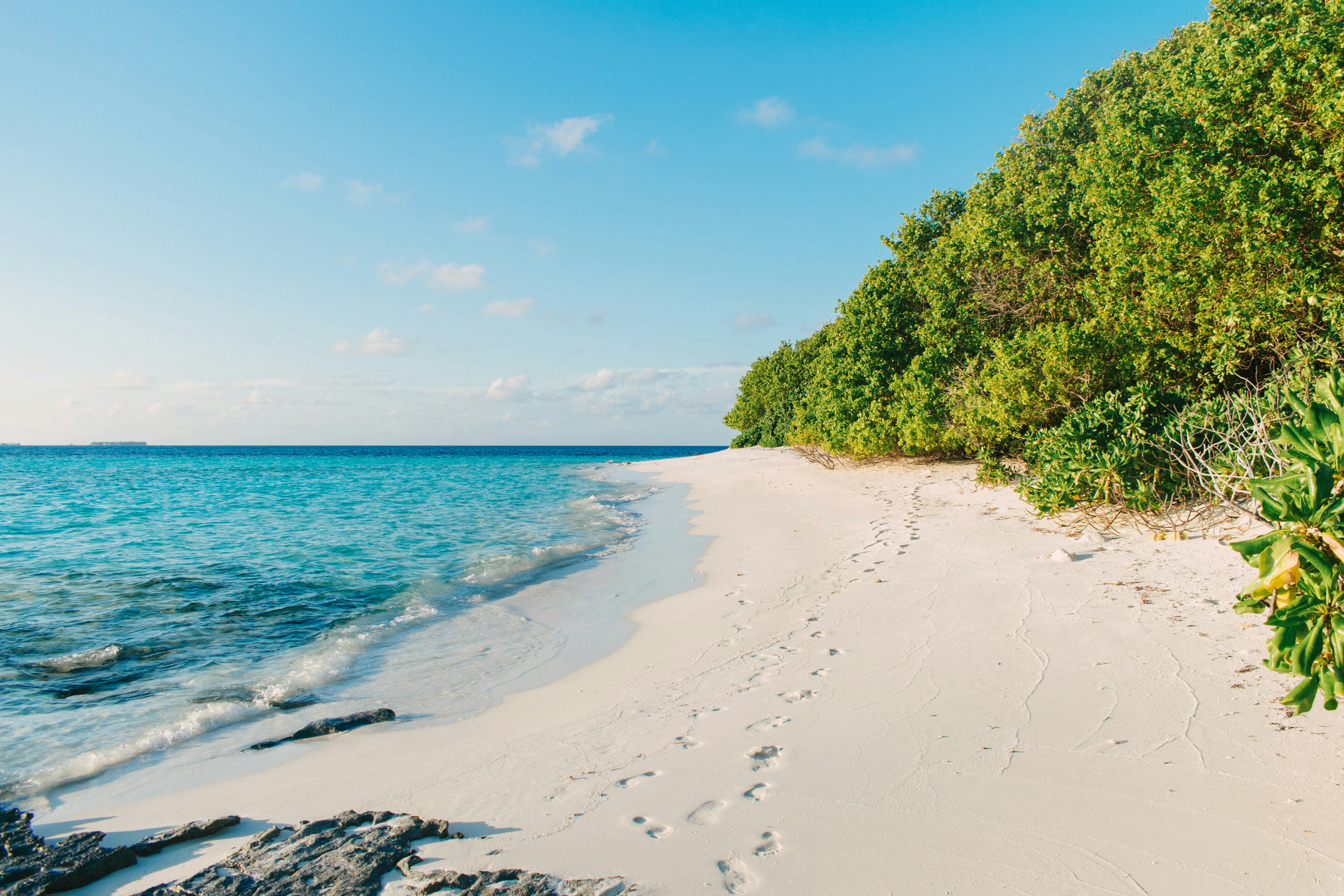 a sandy beach with a few footprints in the sand