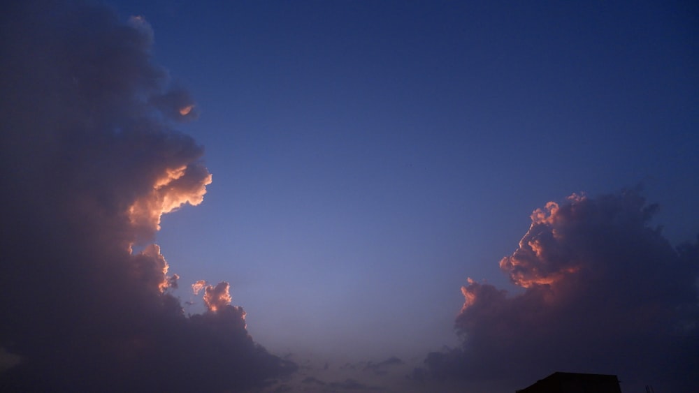 a large cloud in the sky with a building in the background