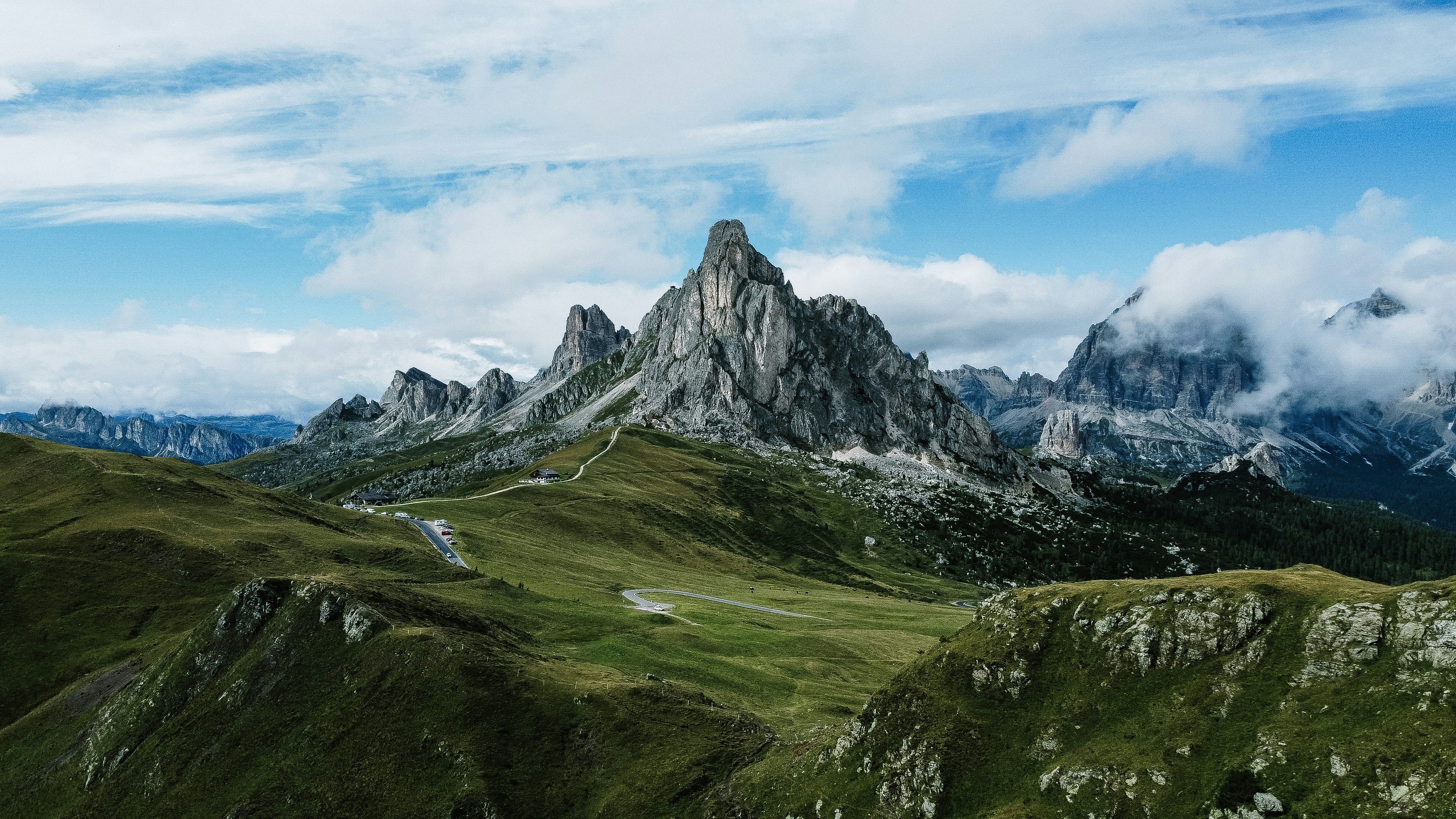 a mountain range with a winding road in the foreground