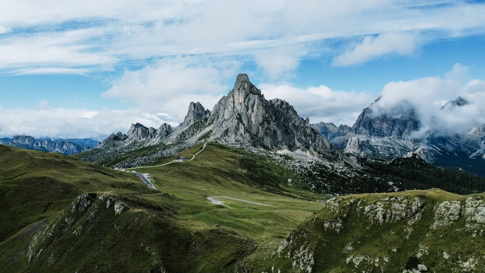 a mountain range with a winding road in the foreground