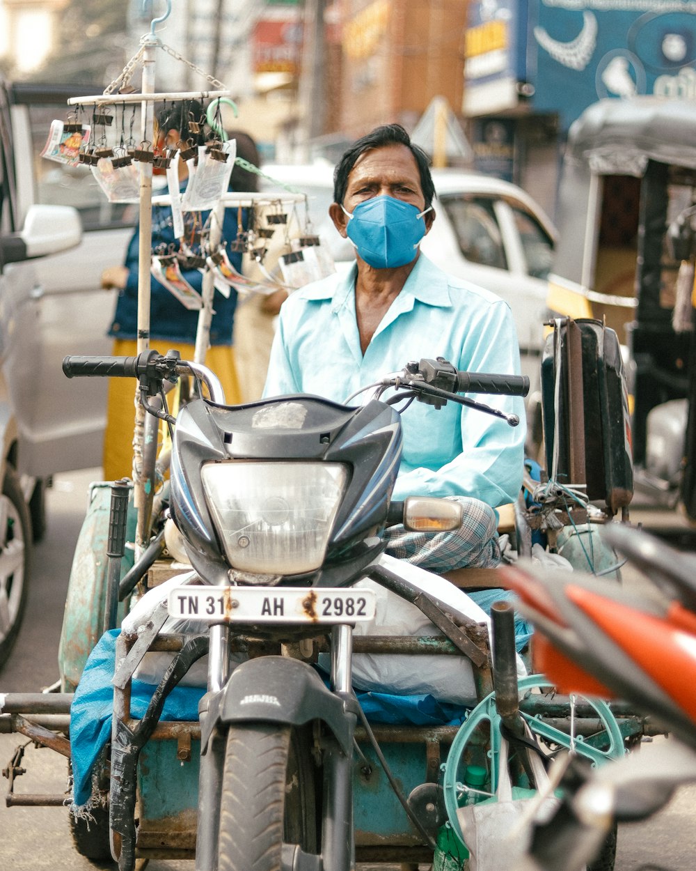 a man wearing a face mask sitting on a motorcycle