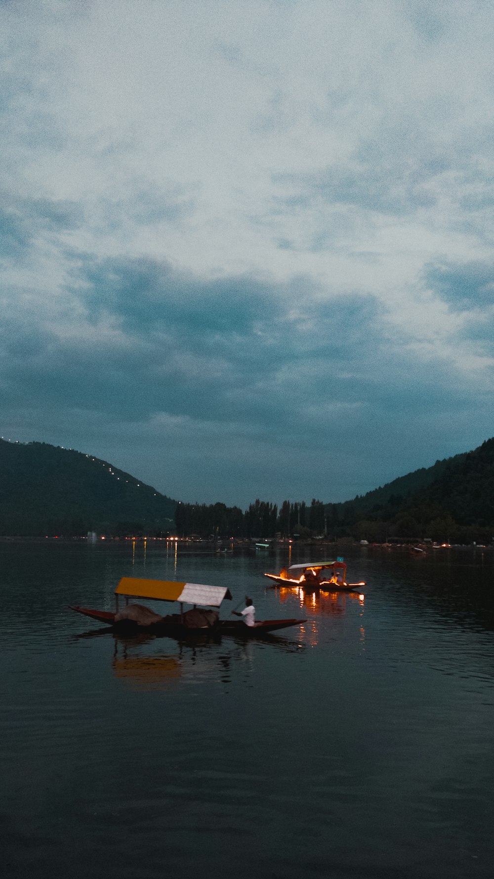 a couple of boats floating on top of a lake