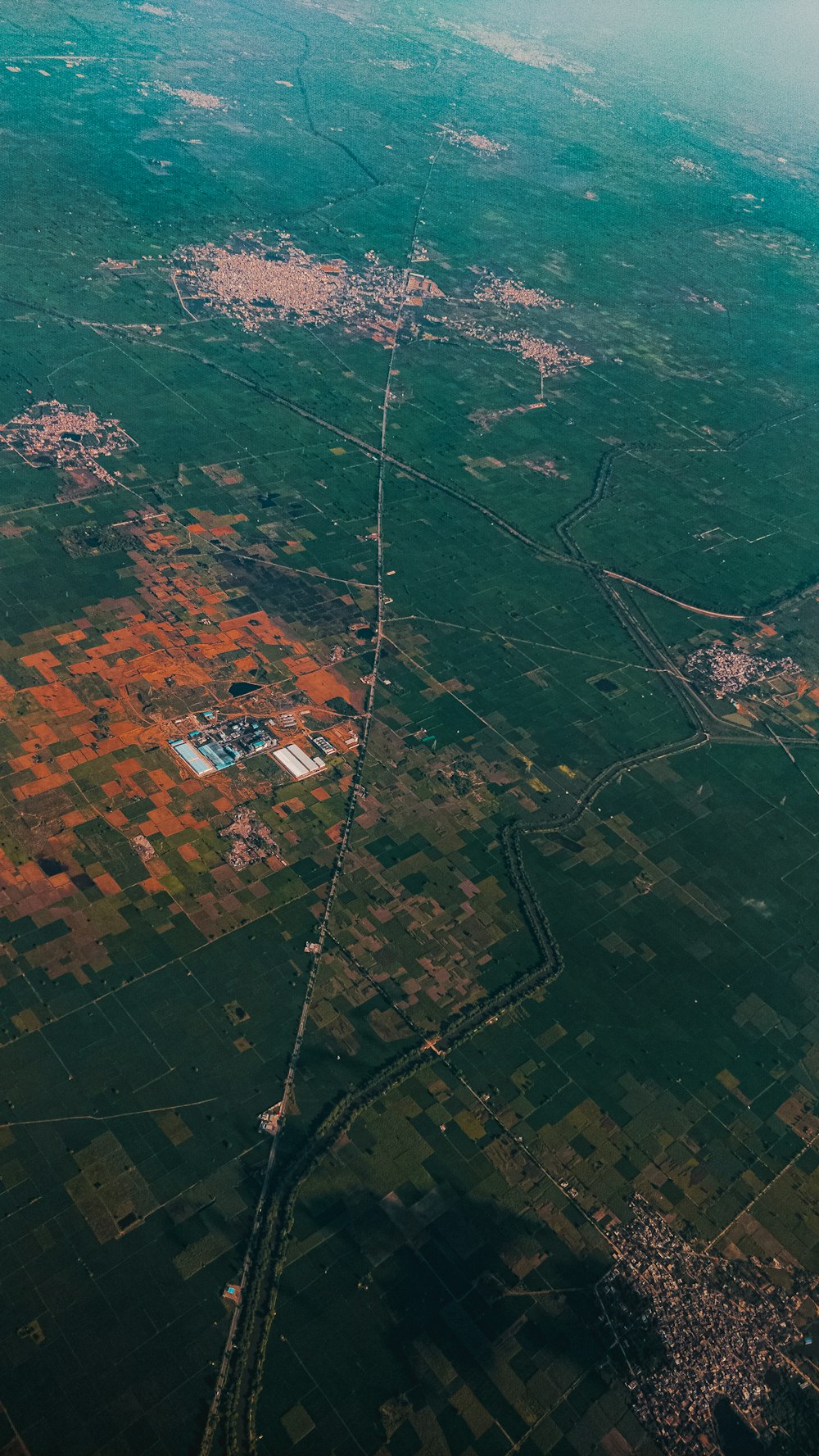 an aerial view of a green field and land