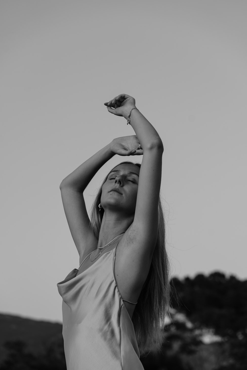 a woman in a white dress holding her arms up