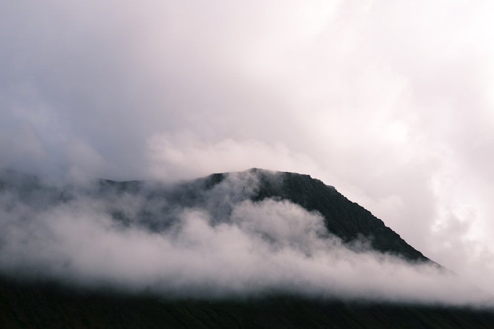 a mountain covered in clouds on a cloudy day