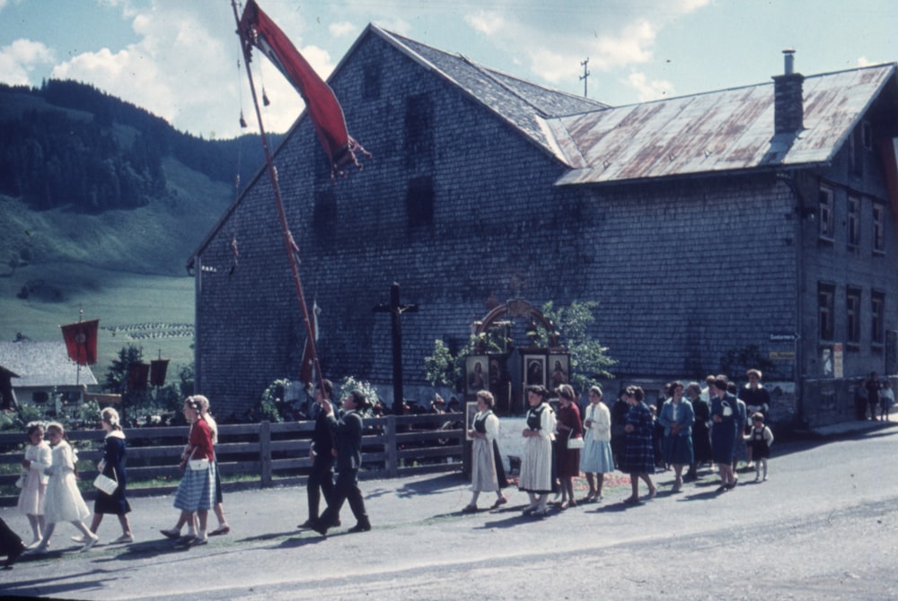 a group of people walking in front of a building