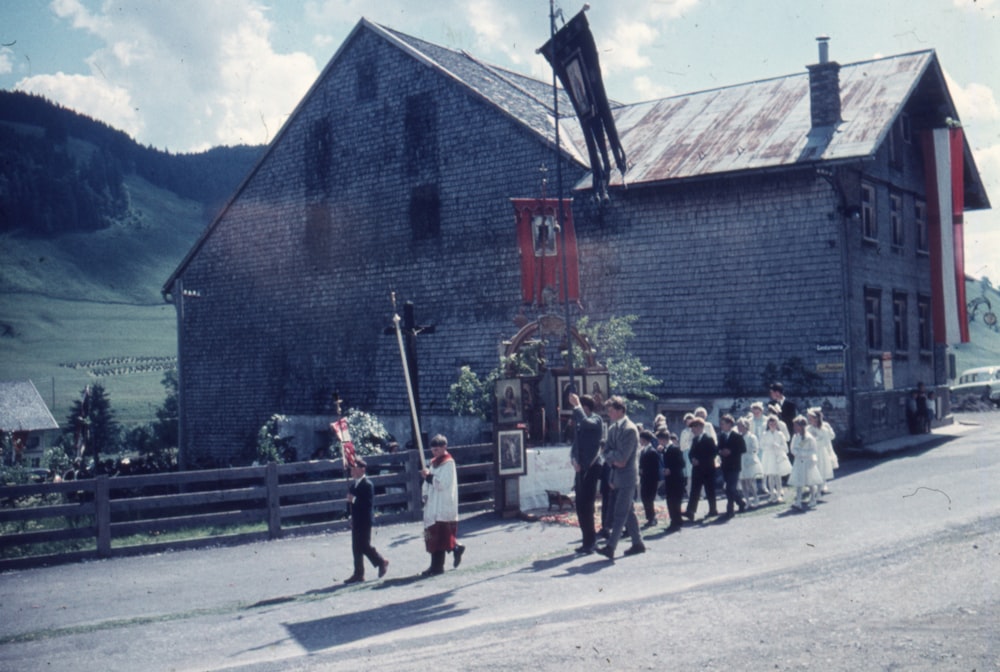 a group of people walking down a street next to a building