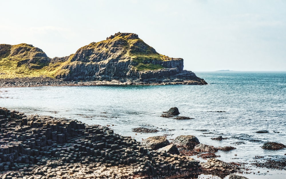 a rocky beach with a small island in the distance