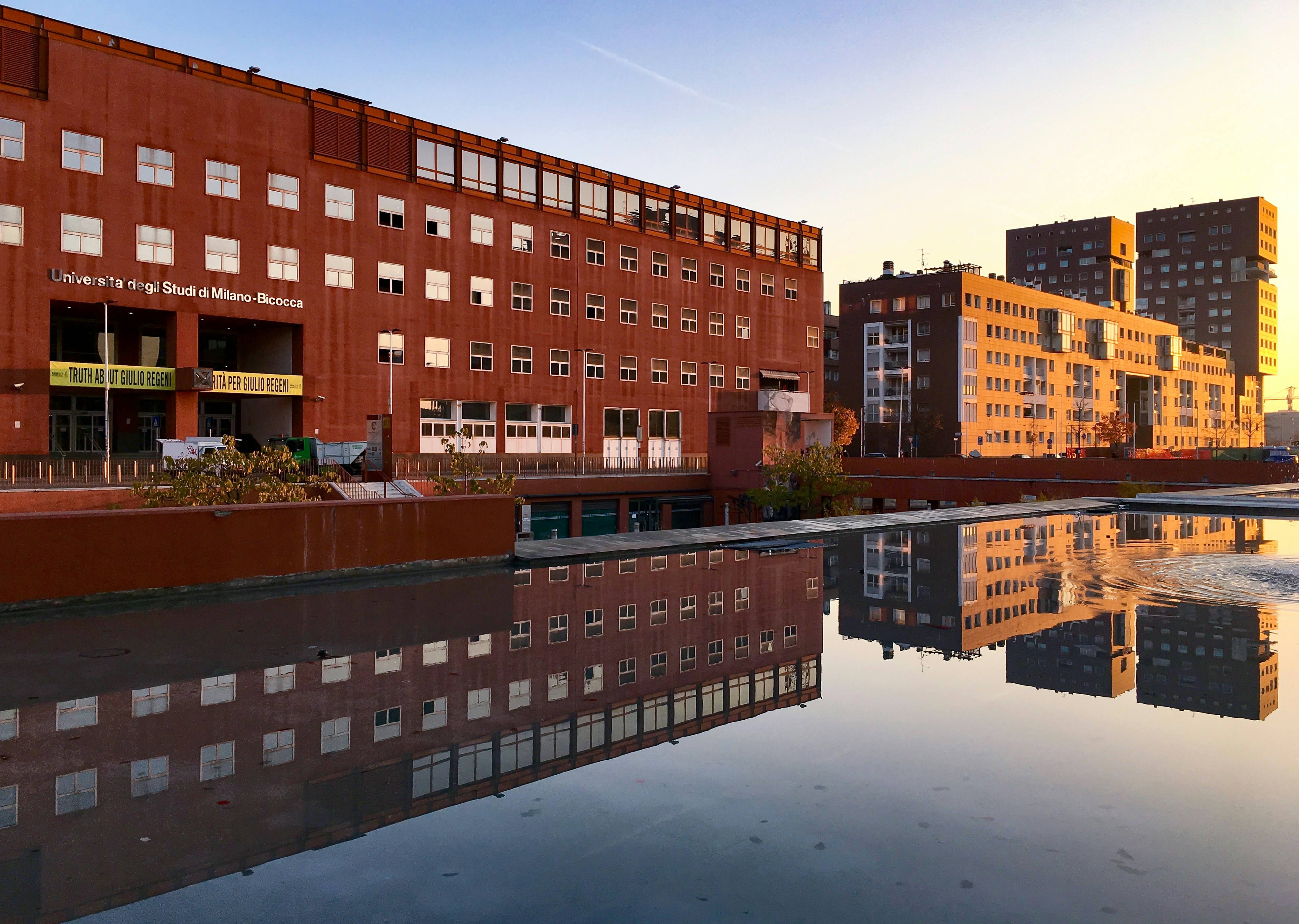 a large body of water in front of a red brick building