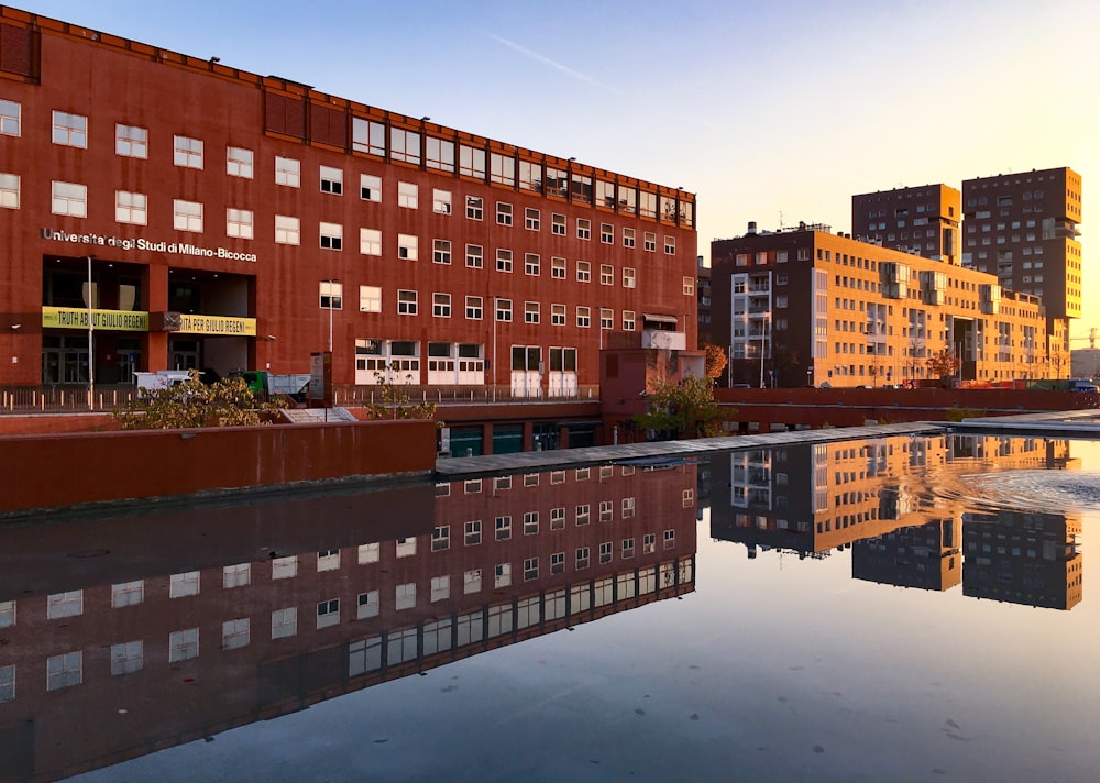 a large body of water in front of a red brick building