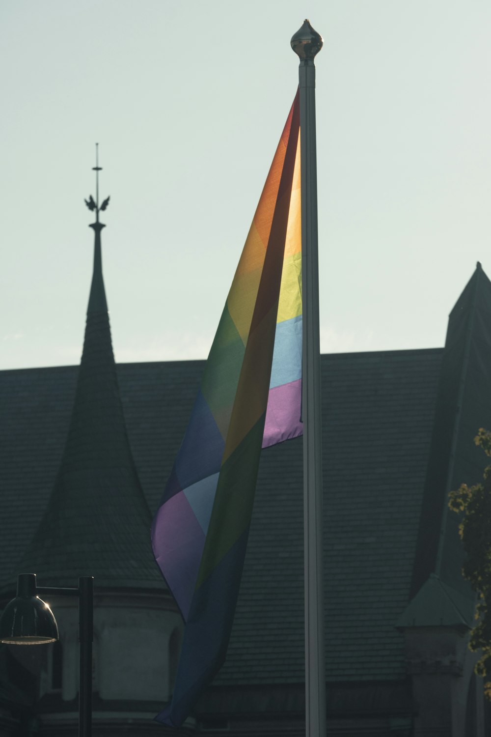a rainbow flag flying in front of a church