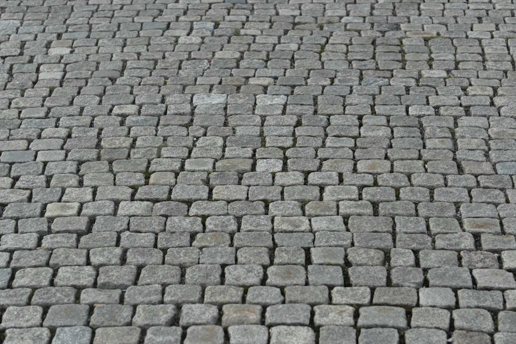 a close up of a brick road with a stop sign on it