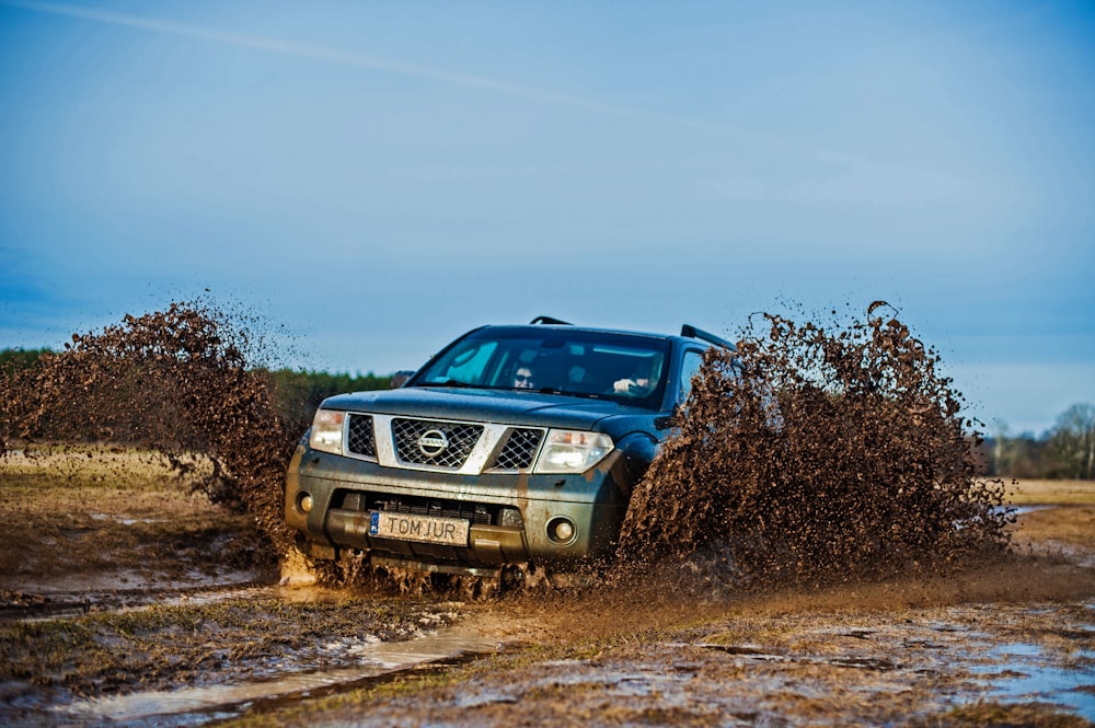 a truck driving through a puddle of mud