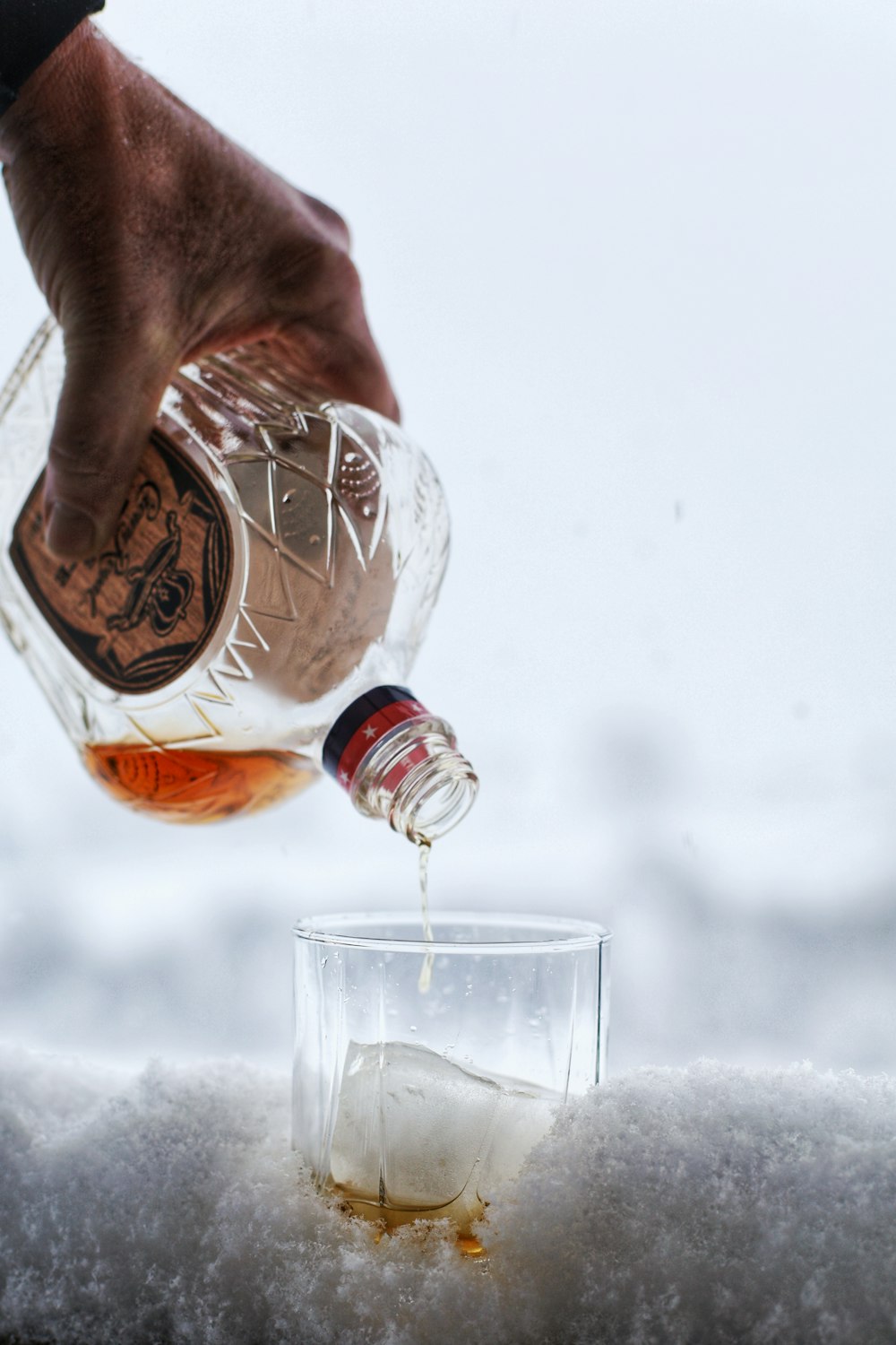 a person pouring a beverage into a glass