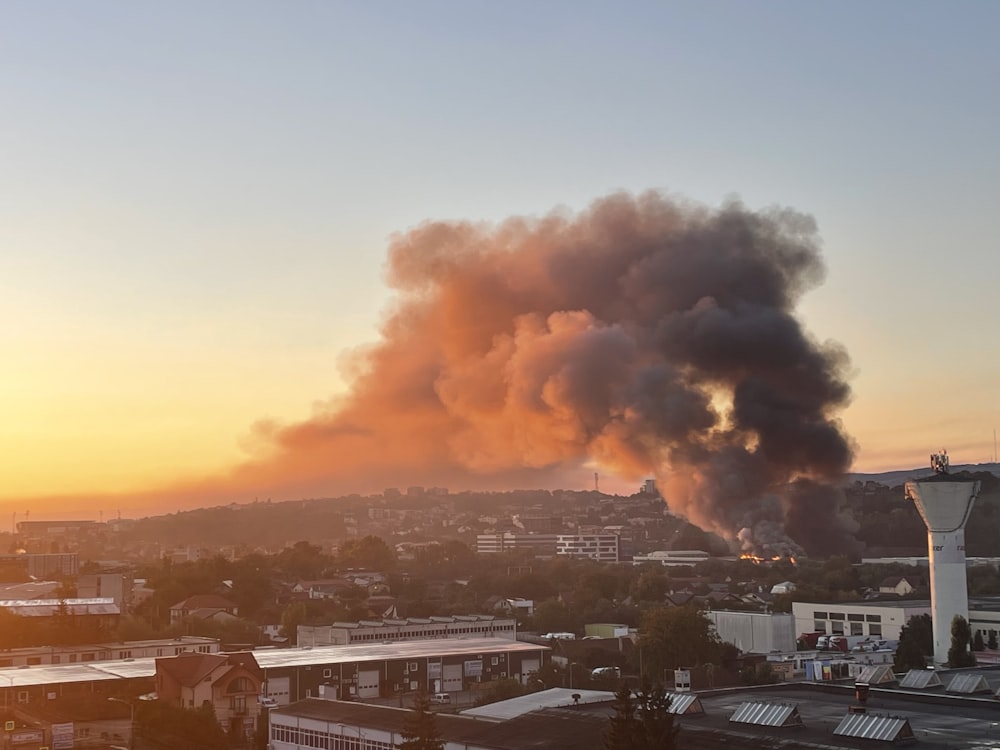 a large plume of smoke billows from a building