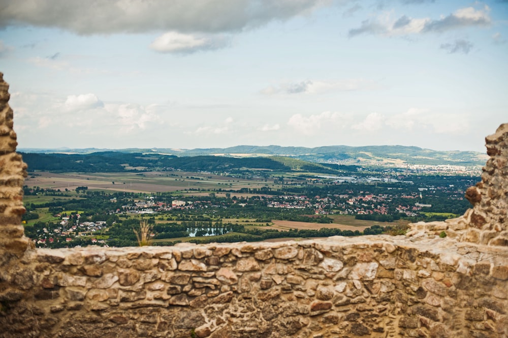 a stone wall with a view of a valley