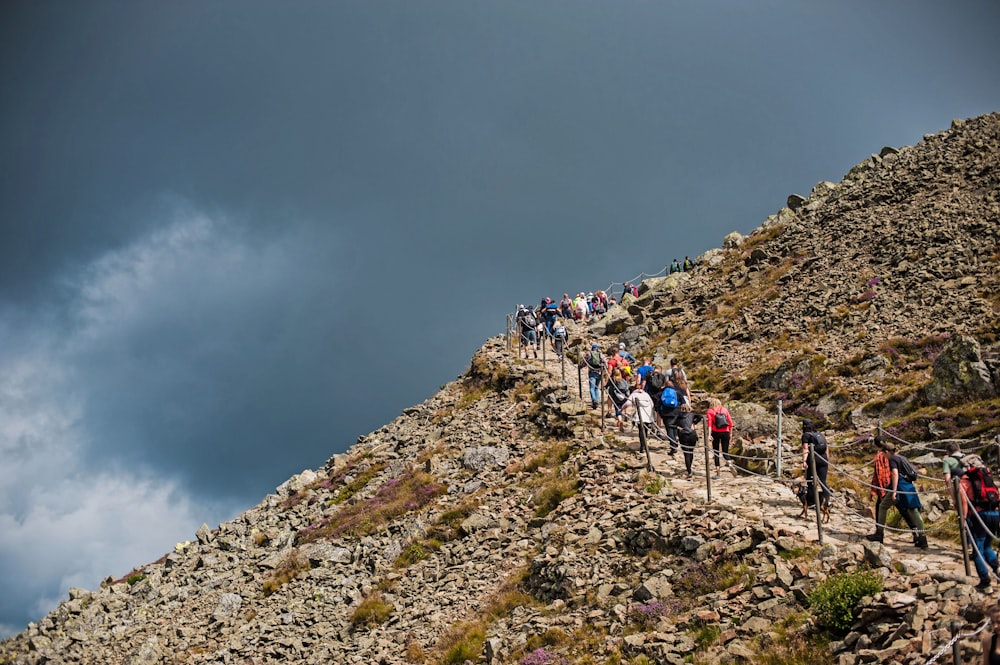 a group of people walking up a rocky hill